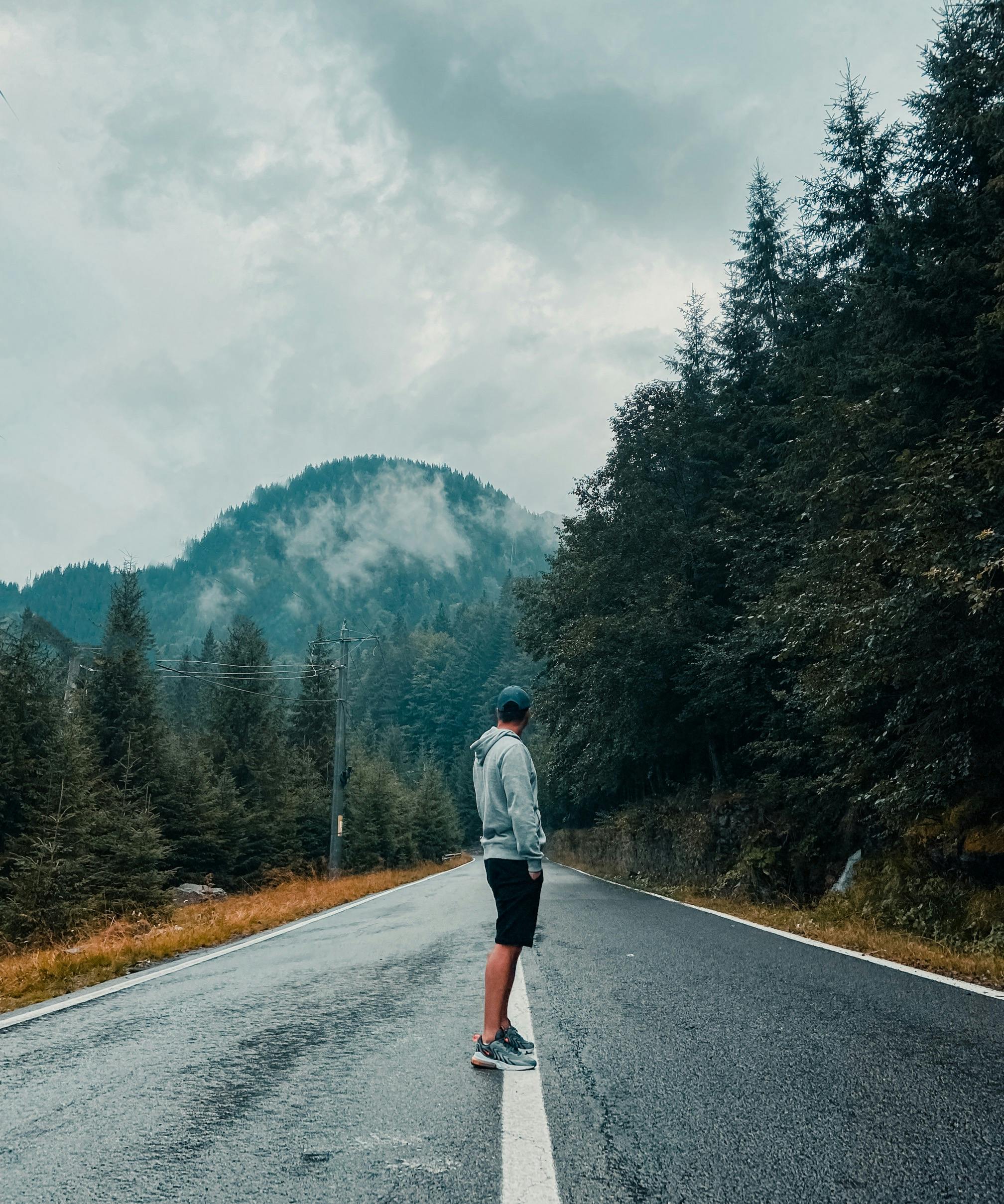 man standing alone on a foggy road symbolizing uncertainty and decision making